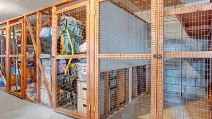 An organized storage space featuring multiple wooden lockers with wire mesh doors.