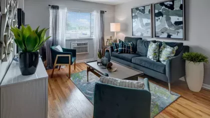 A bright living room showcasing a stylish interior design with abstract artwork and vibrant accents.