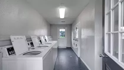 Stylish apartment clubhouse with high ceilings, modern furniture, and a cozy fireplace.