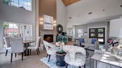 Vibrant pool area with lounge chairs, palm trees, and brick-accented walkways under a clear blue sky.