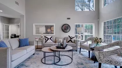 A bright and inviting clubhouse lounge with comfortable seating, large windows, and stylish decor.