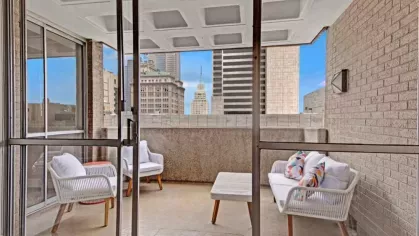 A spacious balcony with seating overlooking the city skyline.