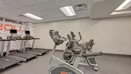 A well-equipped fitness center with treadmills and stationary bikes in a bright and spacious setting.