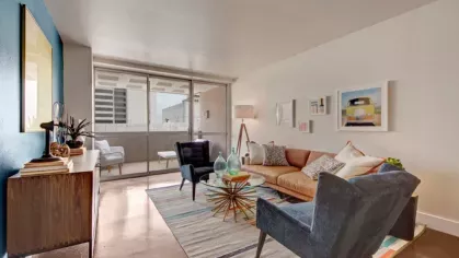 An open concept living area with floor-to-ceiling windows leading to a balcony.