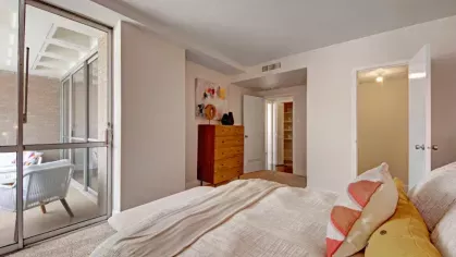 A bedroom with access to a private balcony and ample natural light.