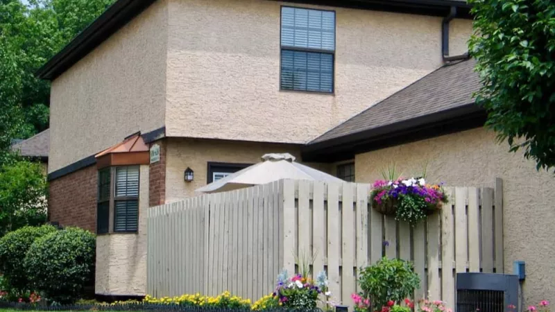 A residential street lined with mature, arching trees providing a shaded and serene setting.