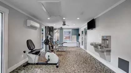 Another angle of the fitness center showing additional machines and a hydration station.