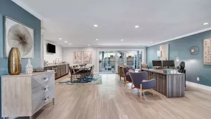 A spacious community room with comfortable seating, workstations, and stylish interior design.