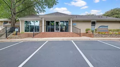 The entrance to Mill Creek Flats, showcasing the main building and parking lot.