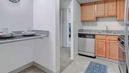 A compact dining nook with a granite breakfast bar set up with tableware.