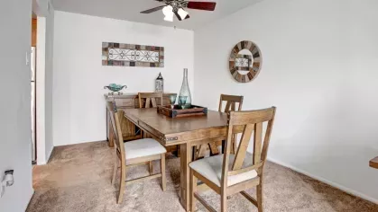 A cozy dining room with a rustic wooden table, chairs, and tasteful wall decor.