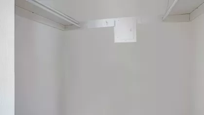 A walk-in closet with neutral walls and sturdy hanging rods, ready for organization.