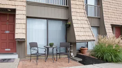 A private patio with a seating area adjacent to sliding glass doors and exterior decor.
