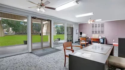 The interior of the leasing office with modern decor and large windows overlooking greenery.