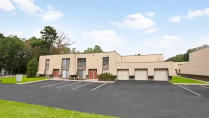 Another angle of the apartment buildings showcasing attached garages and well-maintained surroundings.