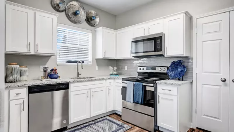 A bright, modern kitchen featuring white cabinetry, stainless steel appliances, and stylish decor.