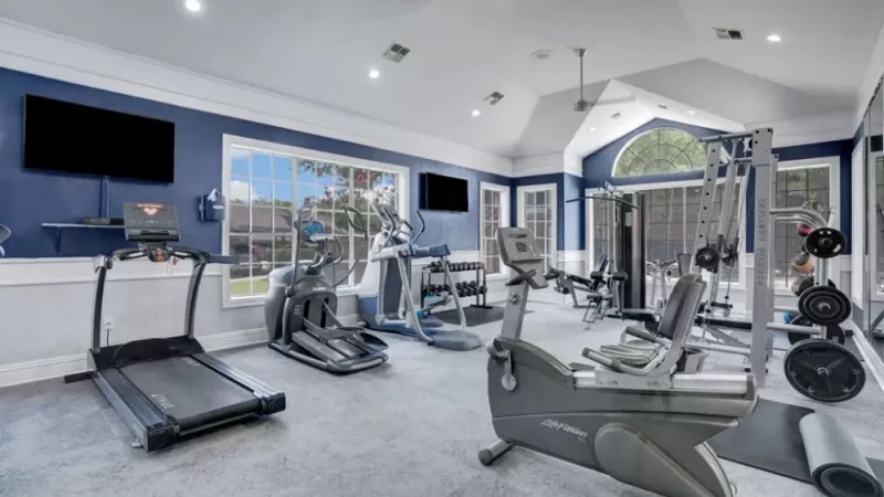 A fully equipped fitness center with treadmills, ellipticals, and strength-training equipment.