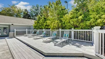 A large sun deck with lounge chairs provides a relaxing spot to soak up the sun near the pool.