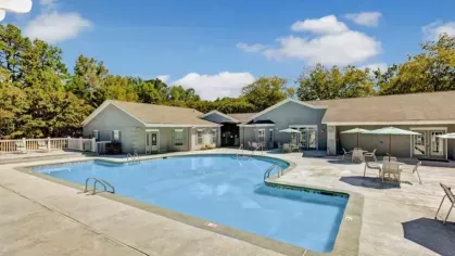 The community’s resort-style pool area is framed by modern amenities and beautiful greenery.