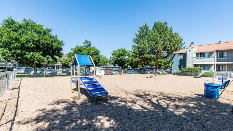 A fenced-in dog park with agility equipment and open play areas.