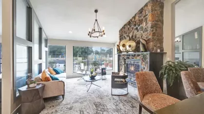 A bright and inviting clubhouse lounge with large windows, comfortable seating, and elegant decor.