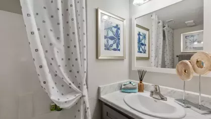 Elegant bathroom at 505 West Apartments with marble countertops, a large mirror, and a clean shower area.