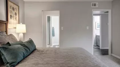 A well-designed bedroom at 505 West Apartments showcasing a view into the en-suite bathroom, highlighting the convenience and functionality of the layout.