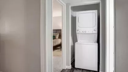 An in-unit laundry space at 505 West Apartments with a stacked washer and dryer, providing convenience and practicality for residents.