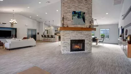 A stylish clubhouse at 505 West Apartments featuring a stone fireplace, comfortable seating, and a spacious lounge area for resident gatherings.