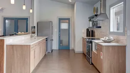 A stylish clubhouse at 505 West Apartments featuring a stone fireplace, comfortable seating, and a spacious lounge area for resident gatherings.