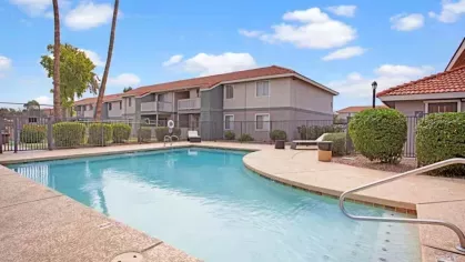 A resort-style pool with shaded seating areas and a spacious deck, perfect for relaxation and social gatherings at 505 West apartments.