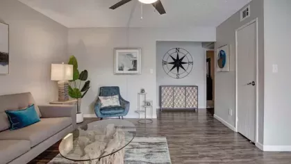 Open living space at 505 West Apartments showcasing wood-style flooring, natural lighting, and sophisticated interior design.