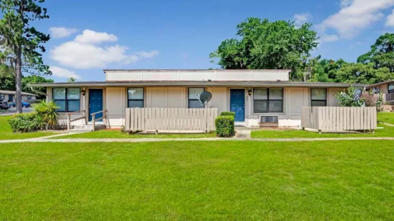 Apartments with unique corner layouts, each featuring personal outdoor spaces and surrounded by manicured landscaping.