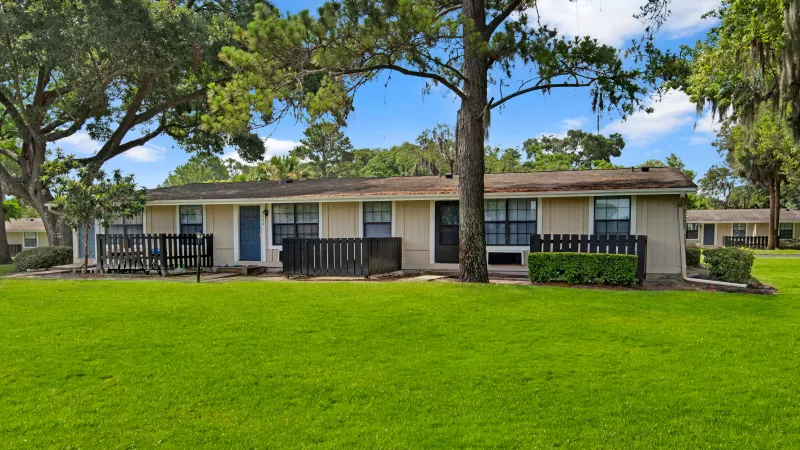 Another view of the single-story apartment units featuring neatly trimmed bushes and vibrant greenery.