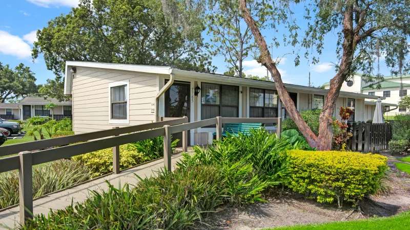Another angle of the apartment ramp showcasing vibrant bushes and a welcoming entrance.