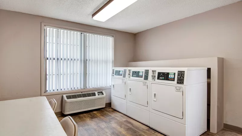 Bright laundry room equipped with modern washing and drying machines.