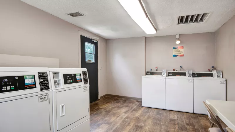Another view of the laundry facility showcasing multiple machines and seating.