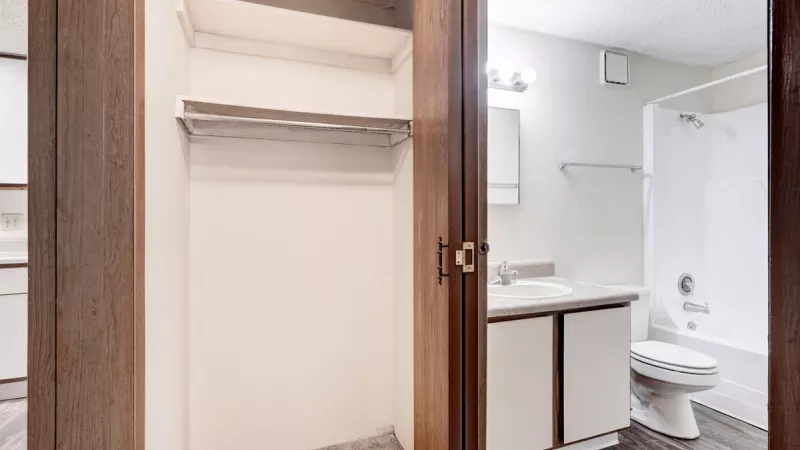 Clean bathroom design at Bridgepoint Apartments with a large mirror, sink vanity, and a shower-tub combination.