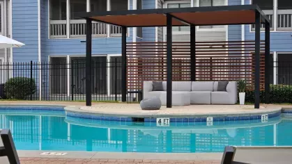 Resort-style pool at Chatsworth Apartments with a shaded gazebo and outdoor seating for relaxation.