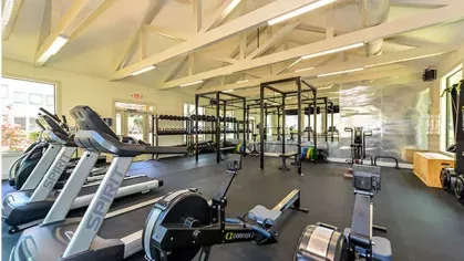 Well-equipped fitness center at Chatsworth Apartments featuring cardio machines, free weights, and a spacious workout area.