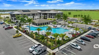 Aerial view of Tropia Wellen Park Apartments, showcasing the landscaped property, resort-style pool, and surrounding green spaces.
