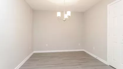 A dedicated dining area with elegant lighting, wood-style flooring, and neutral walls, perfect for intimate gatherings or family meals.