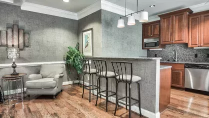 Elegant community lounge with cozy seating, flat-screen TVs, and a kitchenette for resident gatherings or relaxation.