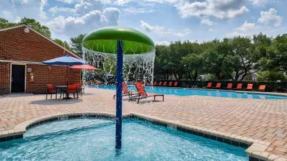 Image showing the spacious outdoor swimming pool at Maple Bay Apartments in Virginia Beach, Virginia, with lounge chairs and umbrellas for a relaxing atmosphere.