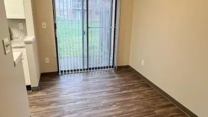 Cozy dining space with wood-style flooring, a ceiling fan, and sliding glass doors leading to a private patio or yard.