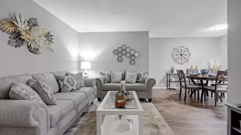 Spacious living room with modern decor, a flat-screen TV, and ample natural light at Norcross Crossings Apartments.