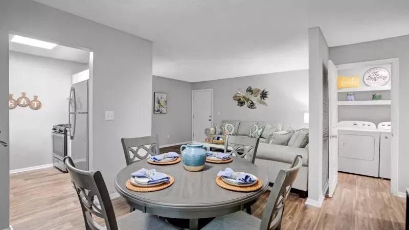Dining area with a sleek table setup and decorative accents adjacent to the living space.