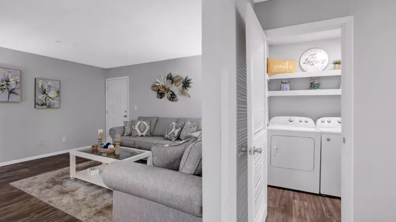 Spacious living room with modern decor, a flat-screen TV, and ample natural light at Norcross Crossings Apartments.