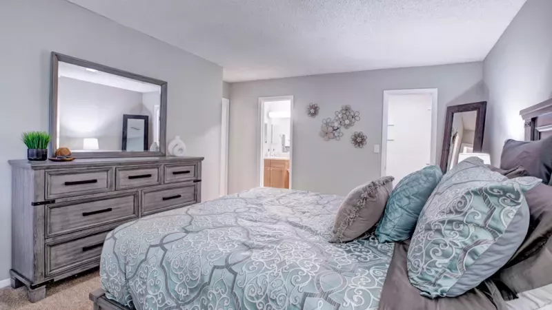 Cozy bedroom featuring plush carpeting, stylish furniture, and soft lighting.