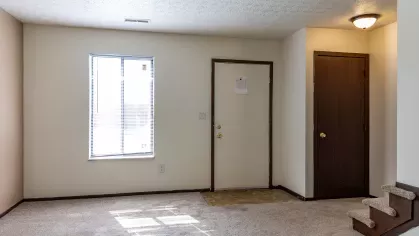 A spacious living room with plush seating and a dining area, showcasing the cozy and welcoming interiors of North River Place Apartments